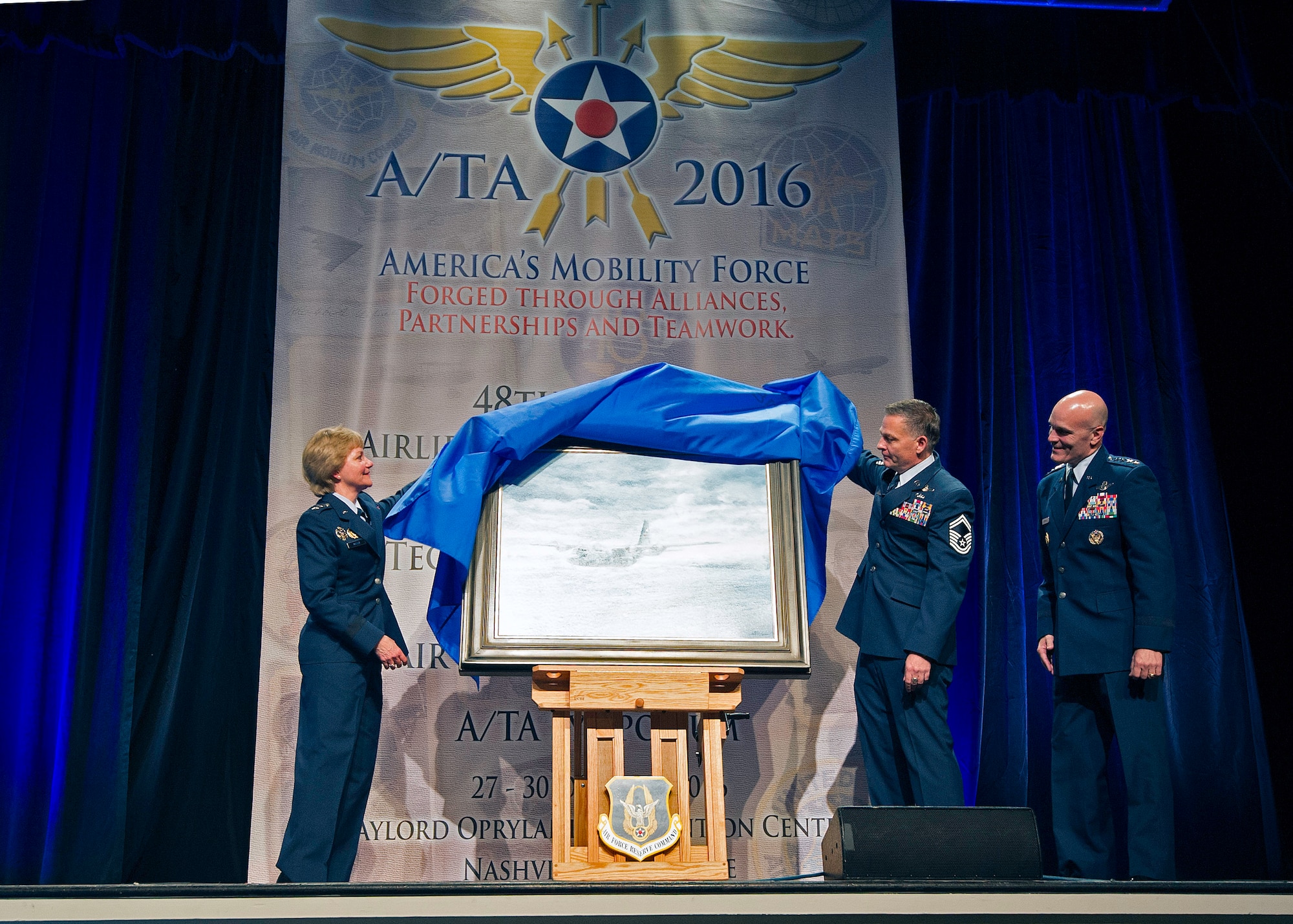Lt. Gen. Maryanne Miller, chief of the Air Force Reserve, Senior Master Sgt. Darby Perrin, and Gen. Carlton D. Everhart III, Air Mobility Command commander, unveil the painting "Deepwater Horizon" at the 48th annual Air Mobility Command and Airlift/Tanker Association Symposium in Nashville, Tennessee. The painting, created by Perrin, is the newest addition to the Air Force Art Program depicts two C-130H Hercules Modular Aerial Spray Systems and Citizen Airmen from the 910th Airlift Wing, Youngstown Air Reserve Station, Ohio, in the cleanup effort following the 2010 BP Deepwater Horizon oil spill. The painting will join nearly 9,000 other works in the Air Force Art Program. These works document the history of Air Force Airmen, equipment, locations and activities. While the 910th AW's aerial sprays are commonly known for insect and vegetation control, the wing has assisted the U.S. Coast Guard with oil spill cleanup for almost 20 years. The cleanup mission lasted five weeks and AF Reserve aircrews sprayed approximately 30,000 acres with oil dispersant during the cleanup effort. (U.S. Air Force photo by Matthew A. Ebarb)