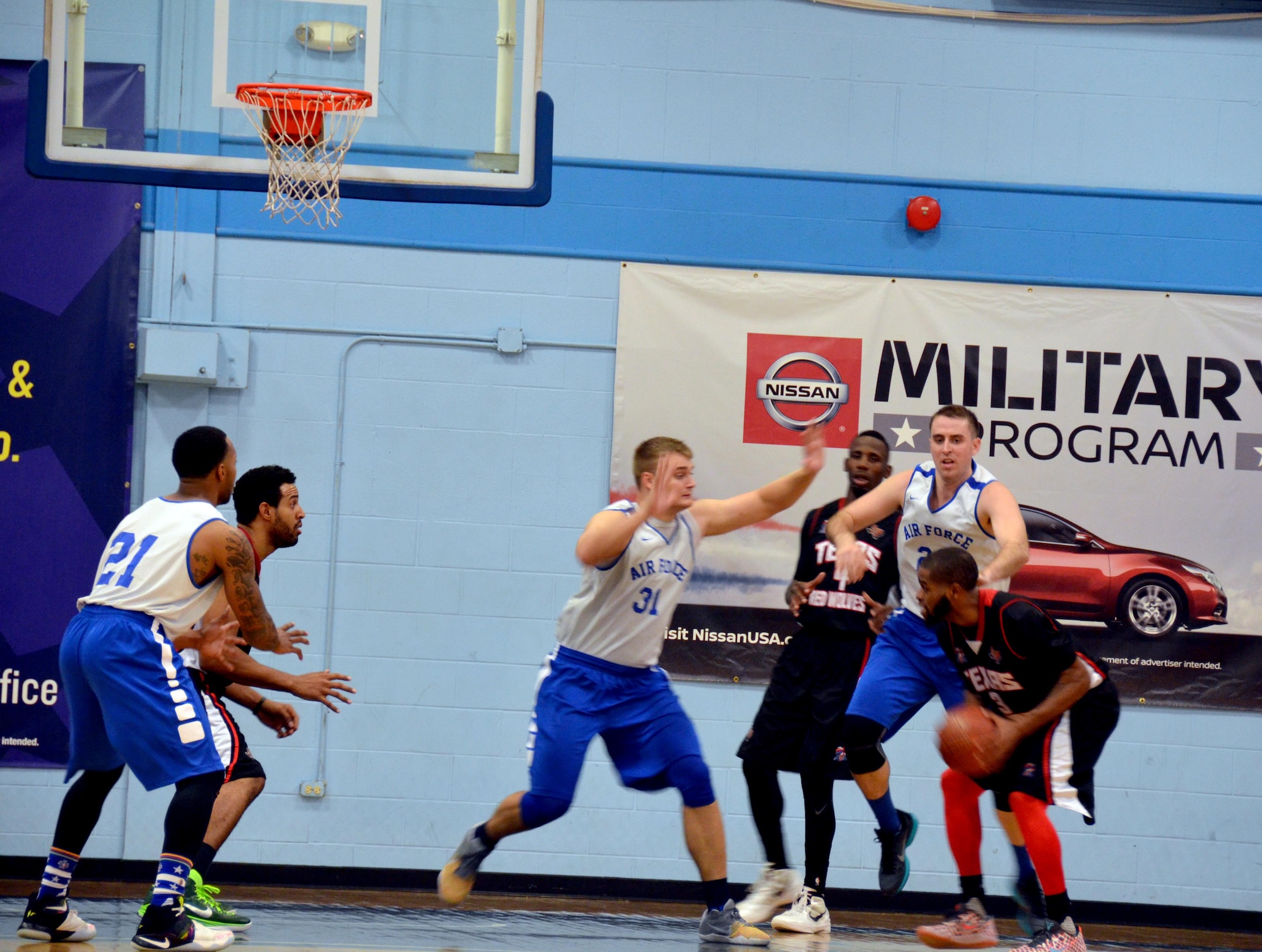 1st Lt. Chase Kammerer (left) and 1st Lt. Michael Fitzgerald try to defend the Texas Red Wolves’ Eric Stewart during the first half at the Chaparral Fitness Center at JBSA-Lackland. (U.S. Air Force photo by Steve Warns)