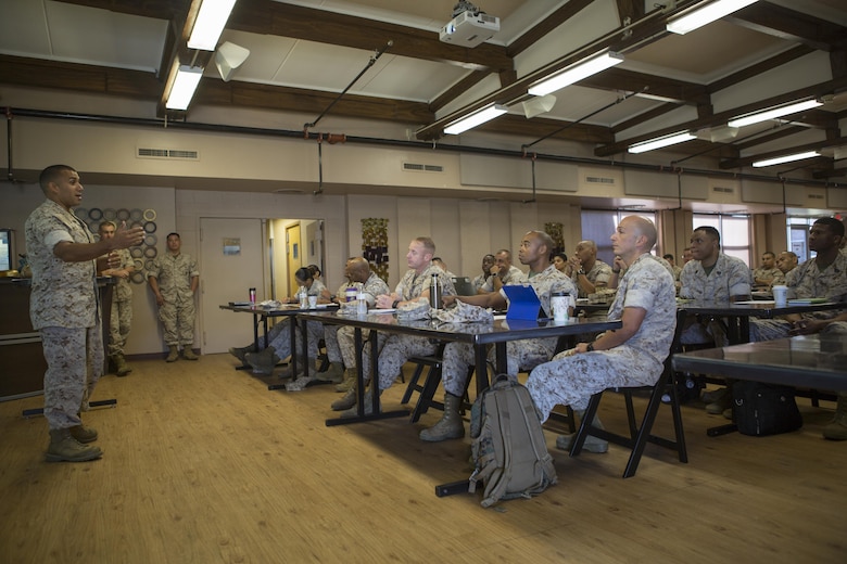 Chief Warrant Officer 3 Alvin G. Figueroa, a senior administrator from 4th Tank Battalion, 4th Marine Division, gives advice to his peers about how the pilot test of the 
Battalion Level Administration Management initiative was successfully implemented at his unit during the 2016 Senior Administrator Symposium aboard Naval Air Station Joint Reserve Base Belle Chasse, La., Oct. 12-13, 2016. The symposium utilized instruction and practical application to help senior administrative personnel understand how and why the implementation of the Battalion Level Administrative Management initiative will improve Reserve units’ ability 
to pass MCAAT inspections. The initiative will mitigate the issues with the current system. (U.S. Marine Corps photo by Sgt. Sara Graham) 
