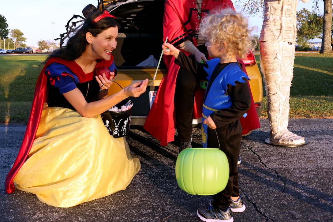Maj. Janine Garner, left, gives Elias, 2, a candy straw during a Trunk or Treat event aboard Marine Corps Air Station Cherry Point, N.C., Oct. 27, 2016. Marine Corps Community Services hosted the Halloween-inspired event that included face painting; touch the truck displays; and a family glow dance party. Decorated trunks were judged and the highest-rated contestants received door prizes. Garner is the commanding officer for Personal Support Detachment 14, Marine Aircraft Group 14. (U.S. Marine Corps photo by Cpl. Jason Jimenez/Released)