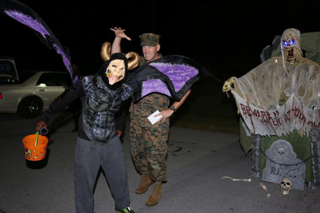 A costumed participant, left, poses in front of Col. Todd Ferry during a Trunk or Treat event aboard Marine Corps Air Station Cherry Point, N.C., Oct. 27, 2016. Marine Corps Community Services hosted the Halloween-inspired event that included face painting; touch the truck displays; and a family glow dance party. Decorated trunks were judged and the highest-rated contestants received door prizes. Ferry is the commanding officer of MCAS Cherry Point. (U.S. Marine Corps photo by Cpl. Jason Jimenez/Released)
