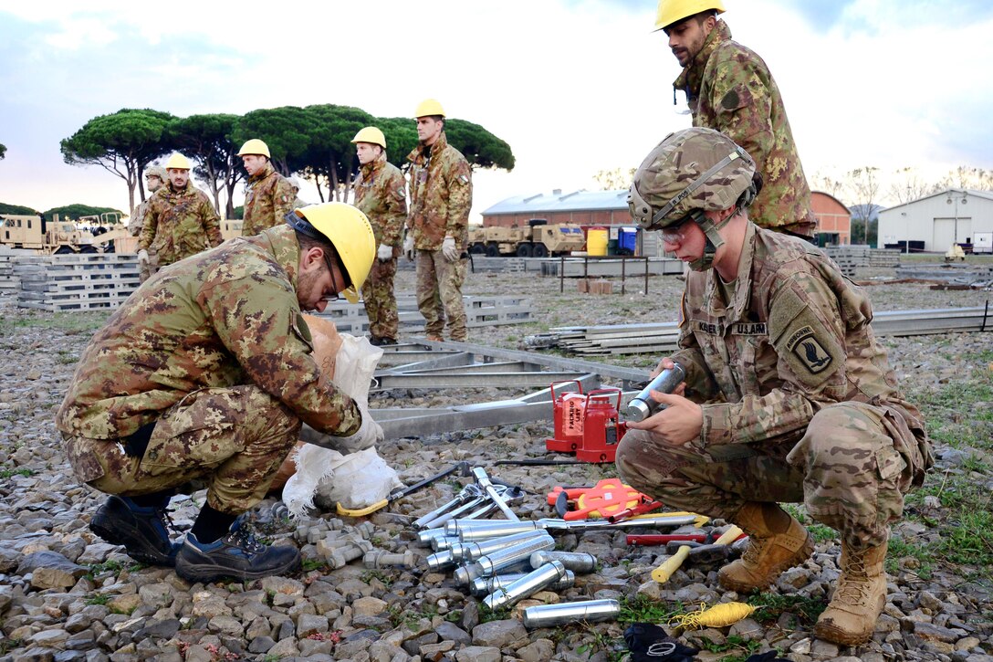 U.S. Army Sgt. Kaitlyne Kisner, right, and an Italian soldier prepare material before assembling a bridge during exercise Livorno Shock at Leghorn Army Depot in Italy, Oct. 21, 2016. Kisner is assigned to the 54th Brigade Engineer Battalion, 173rd Airborne Brigade. The Italian soldier is assigned to the 2nd Engineer Regiment Pointieri Piacenza. The combined readiness exercise familiarizes U.S. paratroopers with river crossing capabilities. Army photo by Elena Baladelli