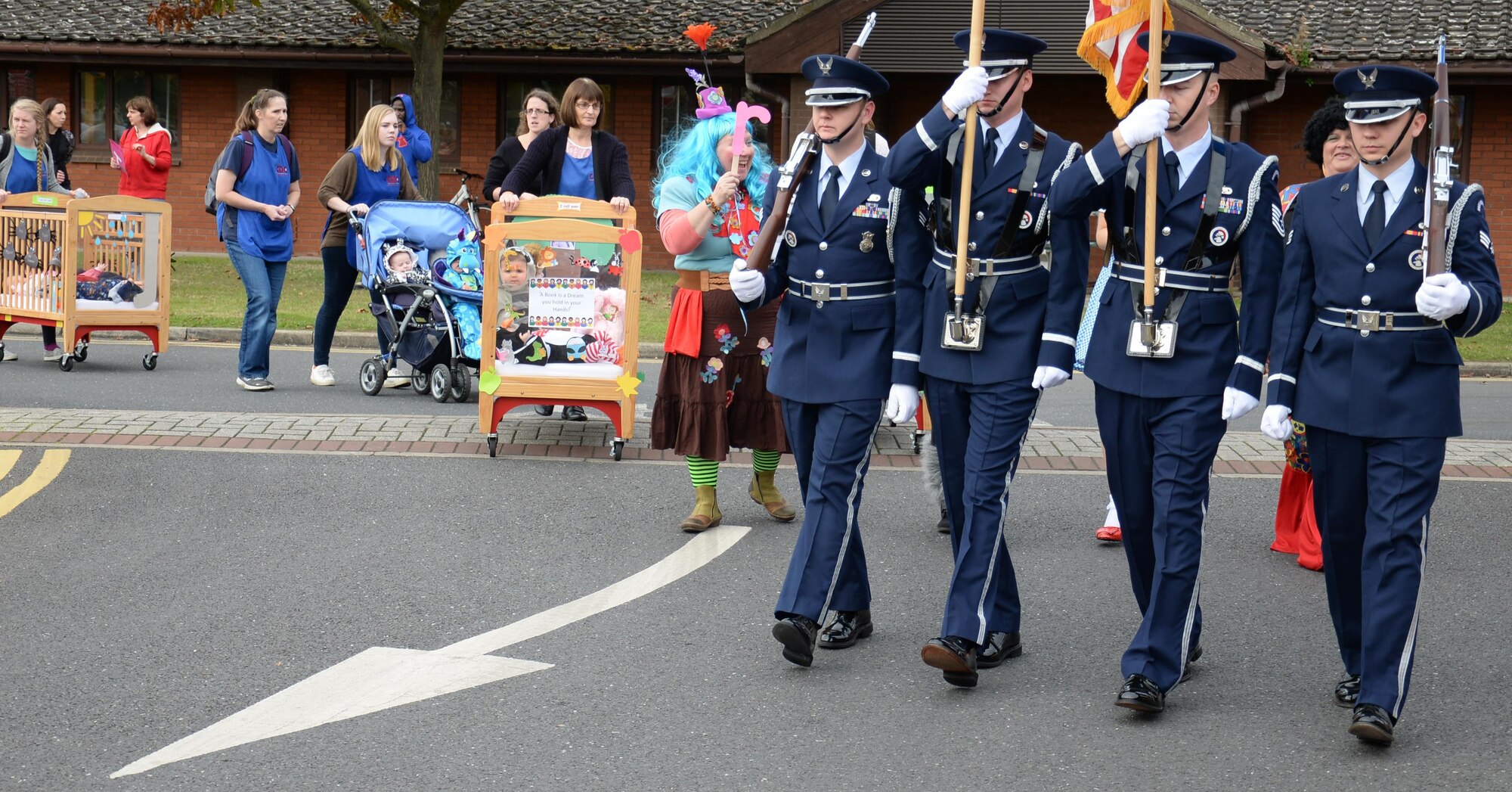 Airmen from the Team Mildenhall Honor Guard join children to take part in a parade during a Fall Festival Oct. 28, 2016, at the child development center on RAF Mildenhall, England. Children of all ages took part in a parade, games and a pumpkin patch. (U.S. Air Force photo by Gina Randall)