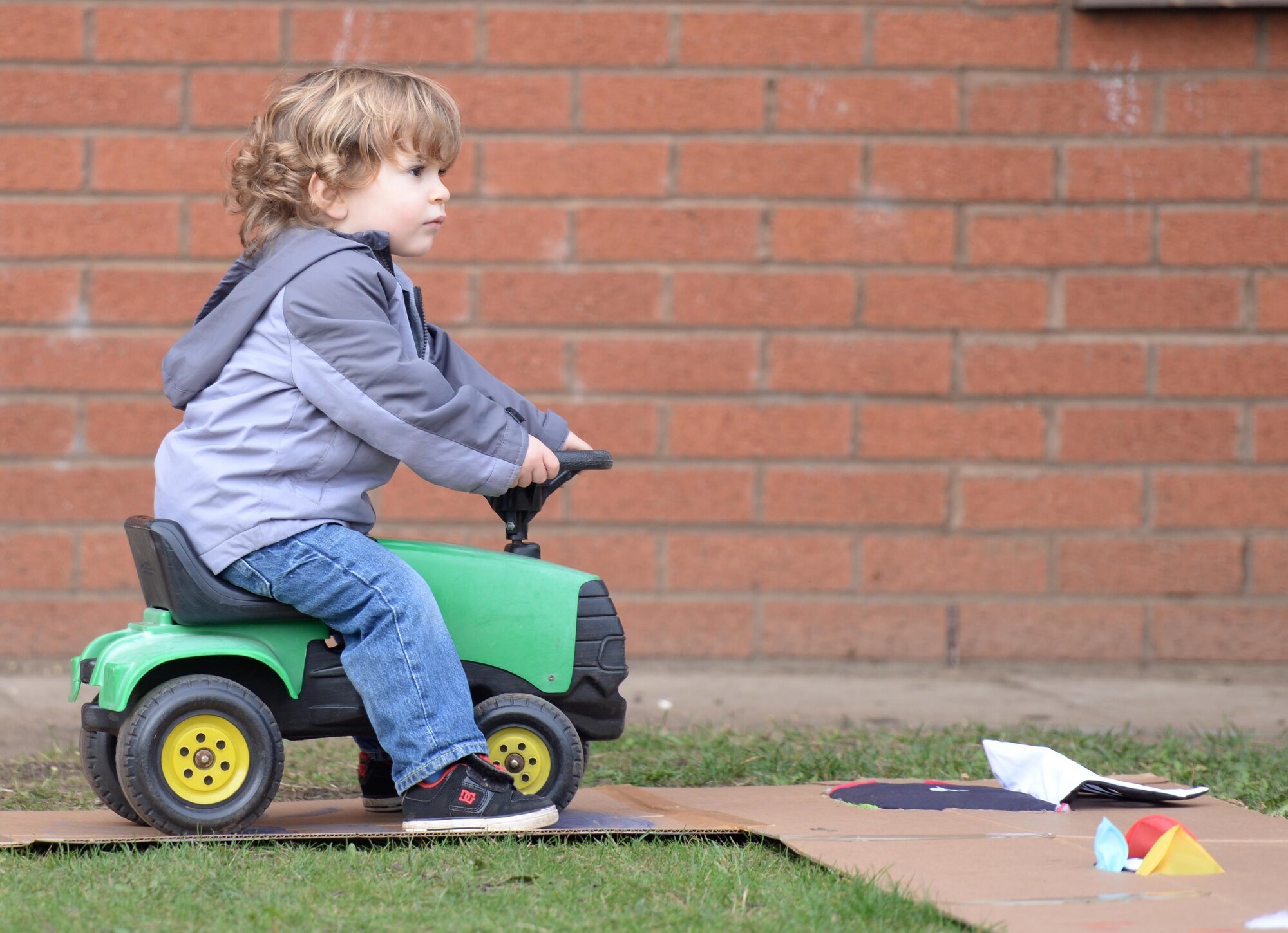 A child plays with a toy tractor during a Fall Festival Oct. 28, 2016, at the child development center on RAF Mildenhall, England. Children and parents took part in a parade then played games and visited a pumpkin patch. (U.S. Air Force photo by Gina Randall)