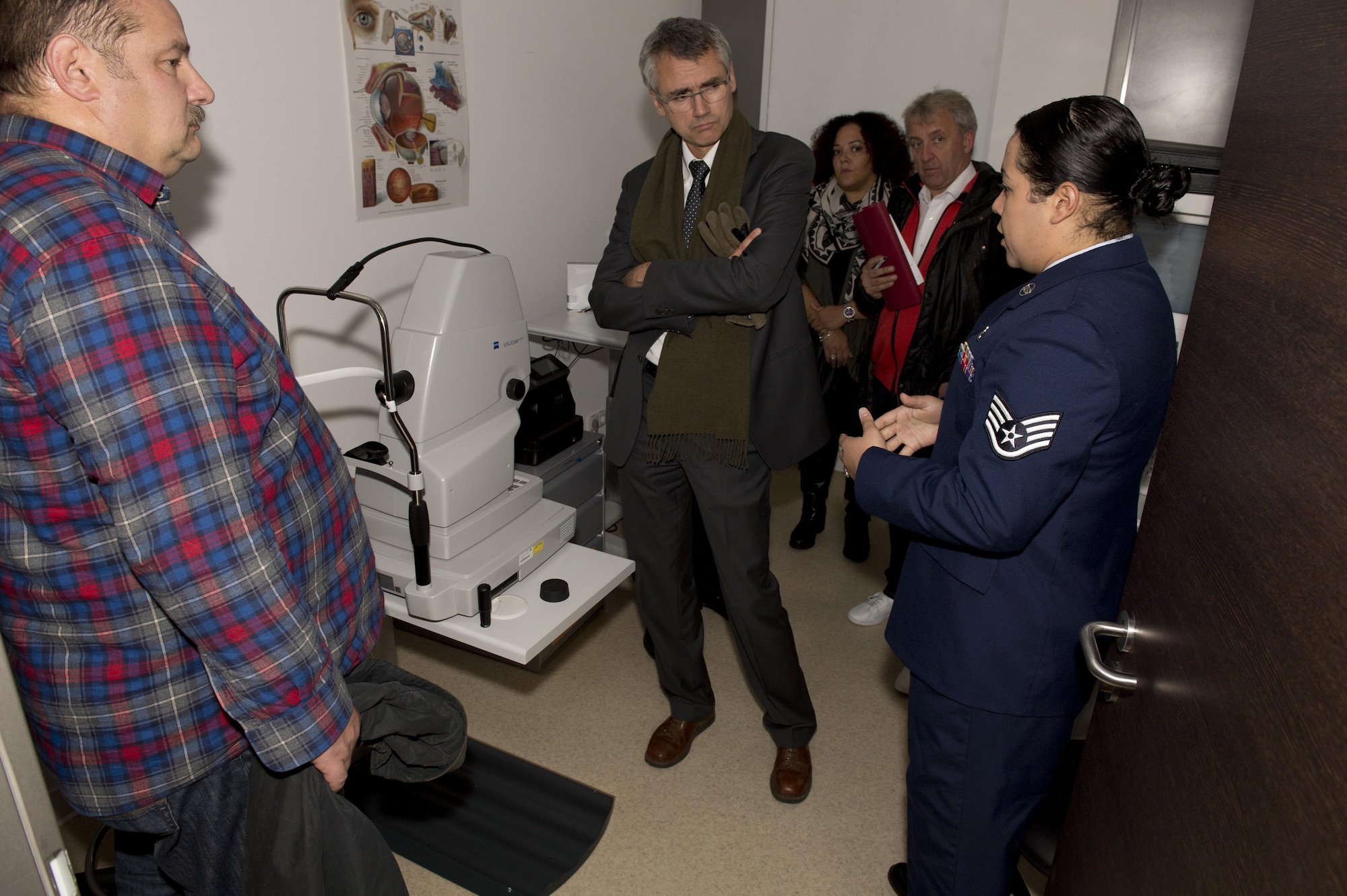 Staff Sgt. Ivonn Denton, an optometry clinic technician at the medical treatment facility at Spangdahlem Air Base, Germany, tells a group of German doctors about the optometry clinic’s optical coherence tomography machine, which measures optic nerve function, during the Spangdahlem MTF’s Eifel Health Consortium Oct. 27. More than 20 German doctors from four major, local hospitals in Bitburg, Trier, and Wittlich, Germany attended the event.  