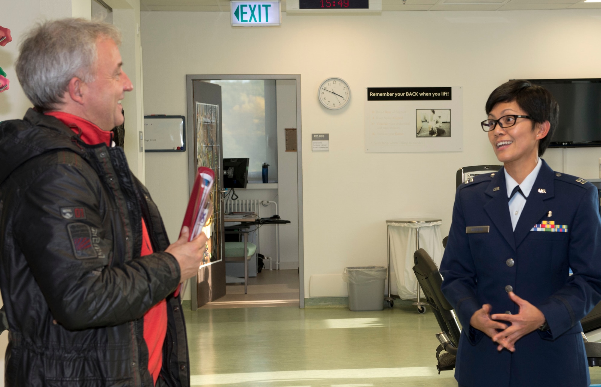 Capt. Jacqueline Astrero, physical therapist at the military treatment facility at Spangdahlem Air Base, Germany, tells Dr. Peter Locher, an obstetrician at the Verbundkrankenhaus Bernkastel, a hospital in Wittlich, Germany, about the medical services the base physical therapy clinic provides during the 52nd Medical Group’s Eifel Health Consortium on base Oct. 27. Locher has delivered around 800 Spangdahlem babies in the past 10 years. 