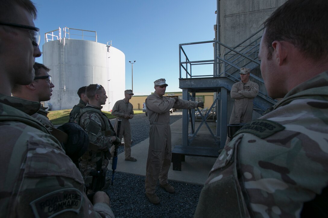 Sgt. Sean Litchfield, close-quarters battle instructor, Training Co., Marine Corps Security Forces Regiment, speaks to service members from Marine Corps Security Force Battalions Kings Bay, Ga., and Bangor, Wa., along with their British Royal Marine counterparts from 43 Fleet Protection Group Royal Marines about tactics to use in a live-fire house during Exercise Tartan Eagle 16 Phase II, aboard Naval Support Activity Northwest Annex, Chesapeake, Va., Oct. 25. U.S. Marines, sailors and Royal Marines used paint rounds during the force-on-force exercise to create a more realistic training environment. (Official U.S. Marine Corps photo by Sgt. Calvin Shamoon/ Released)