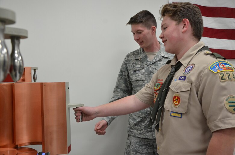 Colben Maher, a Boy Scout from Troop 224 in Melbourne, Fla., opens the door of a gamma ray detector under the watchful eye of Senior Airman Nicholas Jarvis, a radiochemistry lab technician with the Air Force Technical Applications Center, Patrick AFB, Fla.  Maher was one of 52 scouts who visited the nuclear treaty monitoring center Oct. 22, 2016 to earn a Nuclear Science Merit Badge with the help of AFTAC Airmen.  (U.S. Air Force photo by Susan A. Romano)