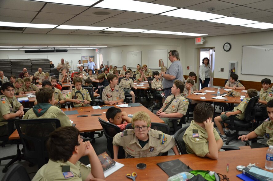 Dr. Dan Mackney (center, standing), a nuclear chemist with the Air Force Technical Applications Center, Patrick AFB, Fla., educates a group of Boy Scouts on nuclear science and technology during the boys’ visit to the base Oct. 22, 2016.  Fifty-two scouts converged at the treaty monitoring center to earn their Nuclear Science Merit Badge with the help of AFTAC Airmen. (U.S. Air Force photo by Susan A. Romano)