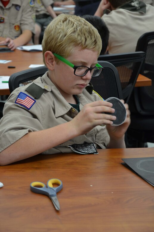 Aidan Moyer, a 7th grader from Stone Middle School and member of Boy Scout Troop 772 in Melbourne, Fla., examines a cloud chamber he made using a plastic a Petri dish, felt, black construction paper and fabric fasteners, which he used to visualize the condensation trails left by ionizing radiation.  Moyer was one of 52 scouts from Brevard County who visited the Air Force Technical Applications Center Oct. 22, 2016 to earn their Nuclear Science Merit Badge with the help of AFTAC Airmen.  (U.S. Air Force photo by Susan A. Romano)