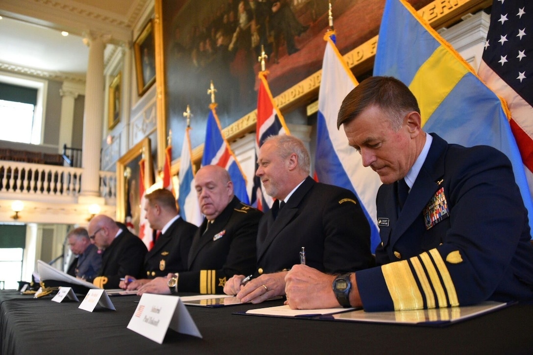 Coast Guard Commandant Adm. Paul Zukunft (right) and the heads of seven other Arctic nations' coast guards sign a joint statement that establishes the frameworks that detail the development of a multi-year strategic plan, avenues to share information, highlight best practices, identify training exercises, and on-the-water combined operations to achieve safe, secure and environmentally-responsible maritime activity in the Arctic in Faneuil Hall in Boston, June 10, 2016. (U.S. Coast Guard photo by Petty Officer 2nd Class Patrick Kelley)