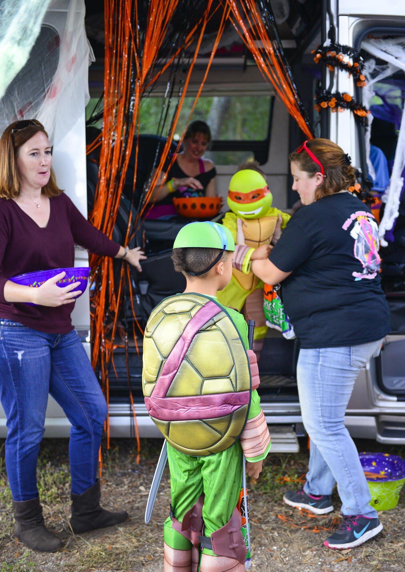 Ninja turtles receive treats at one of the displays at the base’s annual Trunk or Treat event Oct. 28 at Eglin Air Force Base, Fla.  More than 200 parents and children dressed up for the trick or treat event that showcased games and other activities.  (U.S. Air Force photo/Jasmine Porterfield)