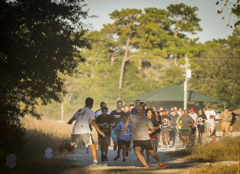 The crowd of runners encounters the first zombies during the annual Zombie Stomp run Oct. 29 at Eglin Air Force Base, Fla.  More than 100 runners participated in ducking, dodging and evading hungry zombies over the 5k course near Base Tango.  (U.S. Air Force photo/Samuel King Jr.)