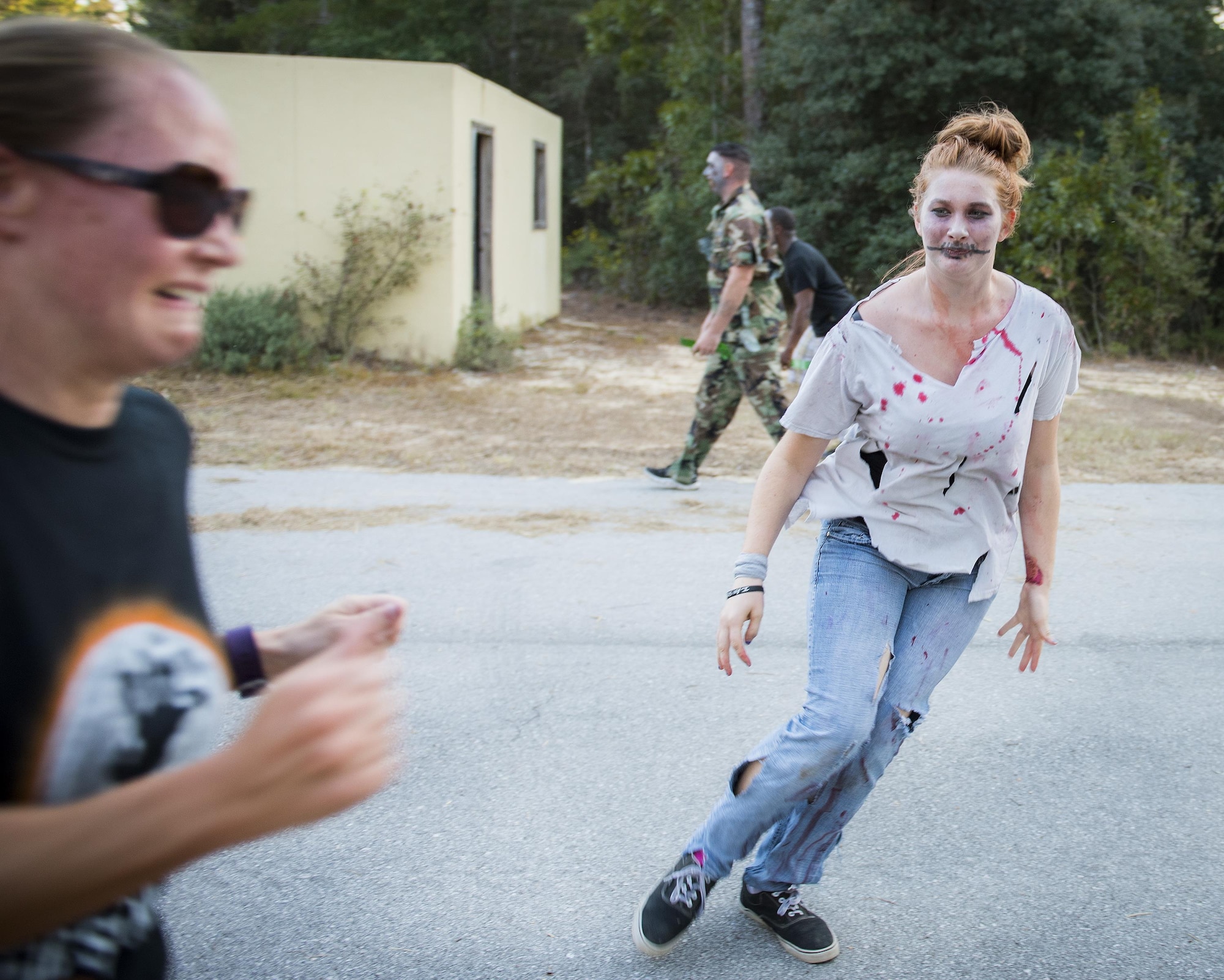 A runner screams in terror as a zombie moves in to get her at the annual Zombie Stomp run Oct. 29 at Eglin Air Force Base, Fla.  More than 100 runners participated in ducking, dodging and evading hungry zombies over the 5k course near Base Tango.  (U.S. Air Force photo/Samuel King Jr.)