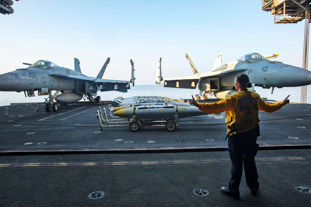 Navy Petty Officer 3rd Class Samantha Finstad acts as the aircraft elevator safety during ordnance transport operations in the hangar bay of the aircraft carrier USS Dwight D. Eisenhower in the Persian Gulf, Oct. 27, 2016. Finstad is an aviation boatswain’s mate (handling). Navy photo by Petty Officer 3rd Class Andrew J. Sneeringer