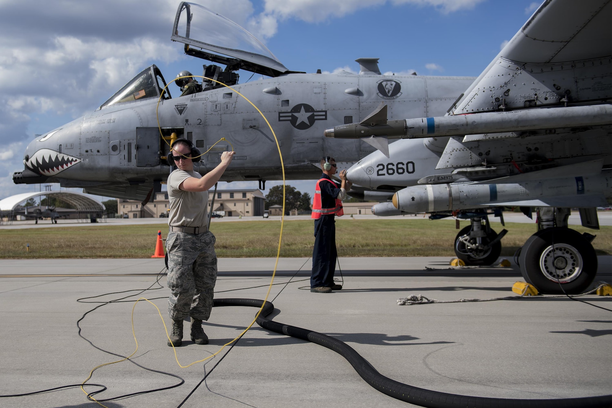 Airman 1st Class Courtney Herll, 23d Logistics Readiness Squadron fuels distribution operator, retracts and stores her refueling equipment from an A-10C Thunderbolt II, while Senior Airman Michael Verheyden, 74th Aircraft Maintenance Unit crew chief, secures the fueling port during a hot refuel, Oct. 26, 2016, at Moody Air Force Base, Ga. Hot refueling is performed on the flightline and takes less than 15 minutes, quickly returning aircraft to the sky. (U.S. Air Force photo by Airman 1st Class Daniel Snider)