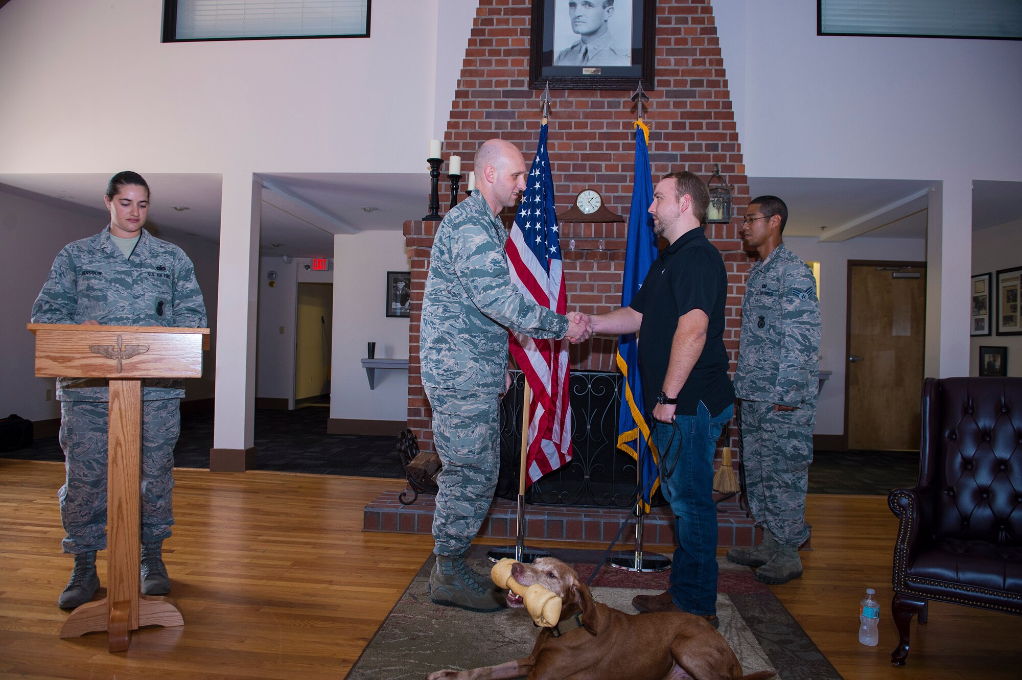 Maj. Charles Tenney, 23d Security Forces Squadron commander, presents retired Military Working Dog Dini to Alexander Nutting, former 23d SFS MWD handler, signifying the adoption of Dini during a retirement ceremony, Oct. 28, 2016, at Moody Air Force Base, Ga. Nutting separated from the Air Force in May 2015 and says he’s glad he fulfilled his promise to come back and adopt Dini. (U.S. Air Force photo by Airman 1st Class Greg Nash)