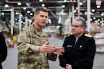 Army Col. Brad Eungard, commander of DLA Distribution Susquehanna, Pa., gives Rear Adm. Guido Cabrera and other members of the Chilean Navy a tour through the Eastern Distribution Center at DLA Distribution Susquehanna, Pa., on October 28.