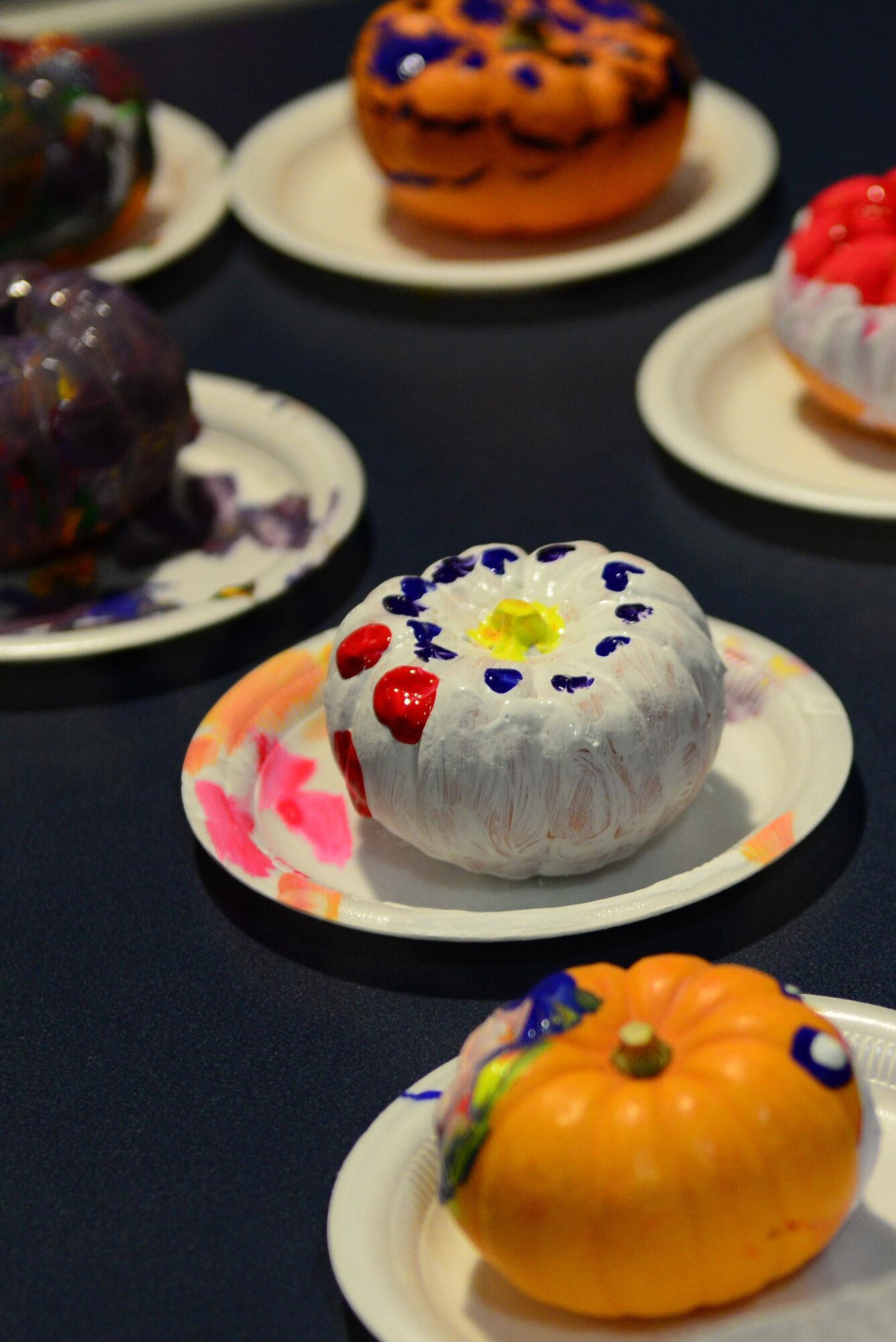 Painted pumpkins dry on a table during the 2016 Fall Festival at the Yukon Club, Oct. 28, 2016, at Eielson Air Force Base, Alaska. After the pumpkins dried, they were placed in a bag and taken home for Halloween. (U.S. Air Force photo by Airman Eric M. Fisher)