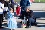 Members of the DLA Distribution Susquehanna, Pa., fire department hand out candy to the children of the Child Development Center during the annual Halloween parade on October 31.