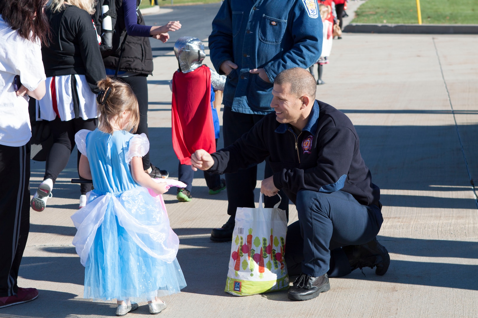 Members of the DLA Distribution Susquehanna, Pa., fire department hand out candy to the children of the Child Development Center during the annual Halloween parade on October 31.