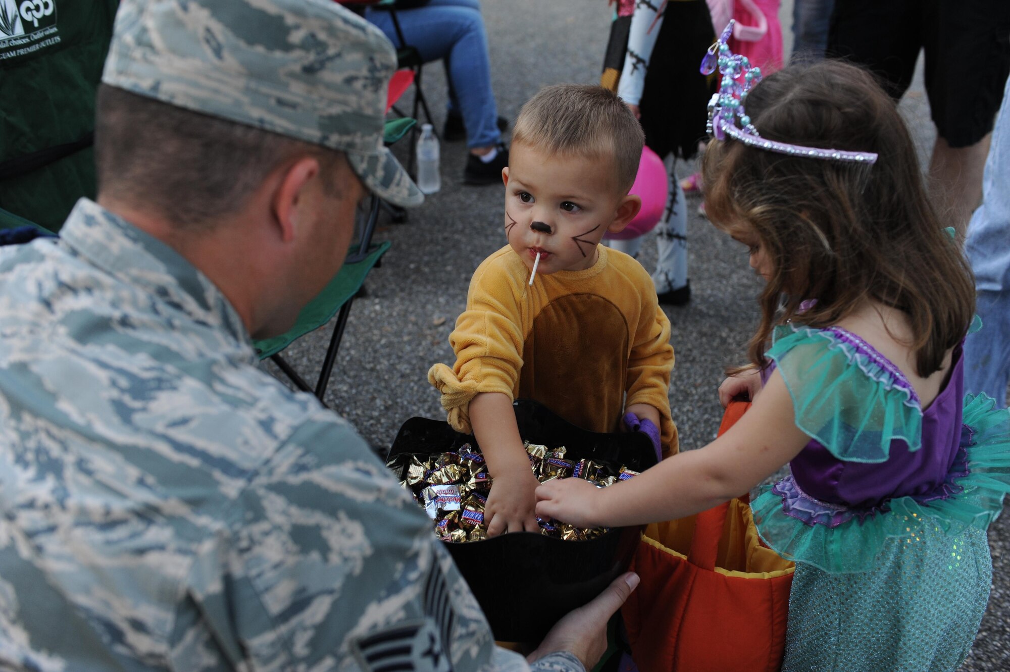 Logan and Peyton Ten Haken, children of Capt. Jason Ten Haken, 333rd Training Squadron instructor, grab candy from Tech. Sgt. Roger Anderson III, 81st Training Group military training leader, during Ghouls in the Park at Marina Park Oct. 28, 2016, on Keesler Air Force Base, Miss. Ghouls in the Park also featured a zombie bus, haunted house and games for children of all ages. (U.S. Air Force photo by Kemberly Groue/Released)