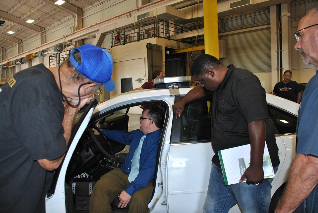 Matthew Campbell of the Air Force Research Laboratory on Wright-Patterson Air Force Base, Ohio, explains one of the idle-reduction systems being tested on security forces vehicles on Joint Base San Antonio-Fort Sam Houston. The study also will be conducted on Offutt AFB, Nebraska. (U.S. Air Force photo by Carole Chiles Fuller)