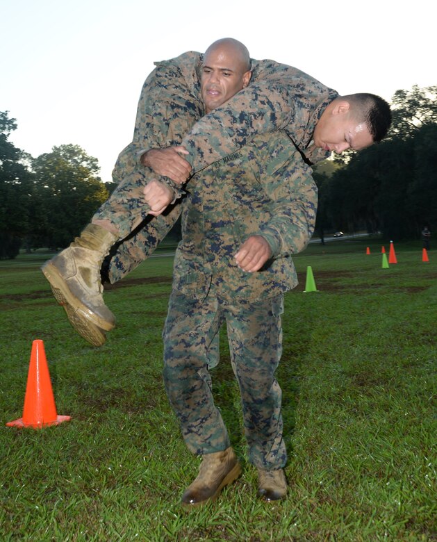 Staff Sgt. Richard A. Soto, supply chief, Marine Forces Reserve, fireman carries Cpl. Andy Phaphilom, armorer, Marine Corps Logistics Base Albany, during the maneuver-under-fire portion of a recent Combat Fitness Test aboard Marine Corps Logistics Base Albany. 