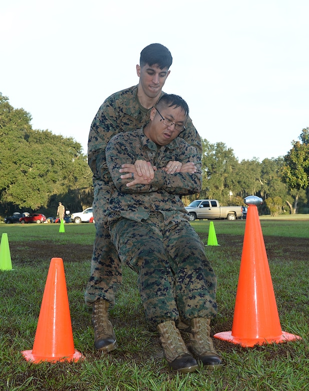 Cpl. Phillip A. Mason, supply administrator, Marine Forces Reserve, fireman carries Sgt. True Vang, warehouse chief, Marine Forces Reserve, during the maneuver-under-fire portion of a recent Combat Fitness Test aboard Marine Corps Logistics Base Albany. 