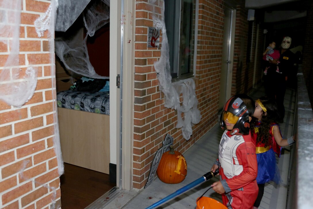 Miguel, 6, left, leads his family into a Halloween-themed barracks room during a Haunted Barracks event aboard Marine Corps Air Station Cherry Point, N.C., Oct. 28, 2016. Marine Wing Headquarters Squadron 2 hosted the event to give Marines living in the barracks an opportunity to celebrate Halloween with other MWHS-2 Marines and their families. Children went door-to-door with their parents and received candy from the Marines.