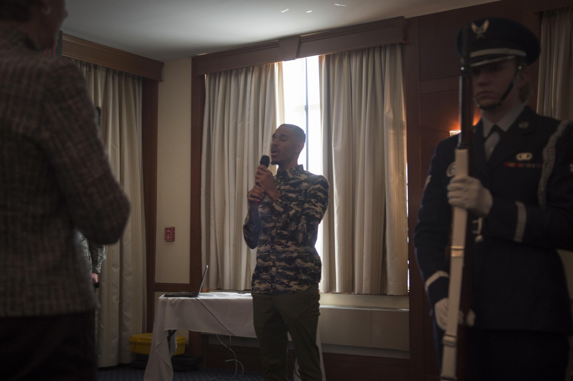 Maurice Cooper, guest vocalist, sings the National Anthem at Retiree Appreciation Day on Joint Base Andrews, Md., Oct. 29, 2016. The event included a health fair and flu shots, and also gave information on Tricare, recreation activities, and more. (U.S. Air Force photo by Senior Airman Mariah Haddenham)