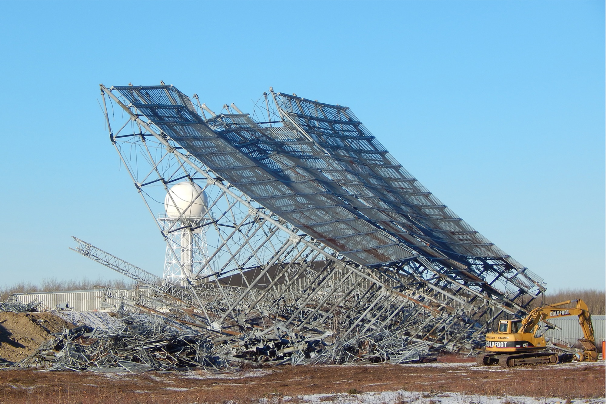 CLEAR AIR FORCE STATION, Alaska – Crews use cables and excavators to demolish the defunct Ballistic Missile Early Warning System radar at Clear Air Force Station, Alaska, Oct. 26, 2016. The radar was taken down and is being removed and recycled to make way for new construction. (Courtesy photo)