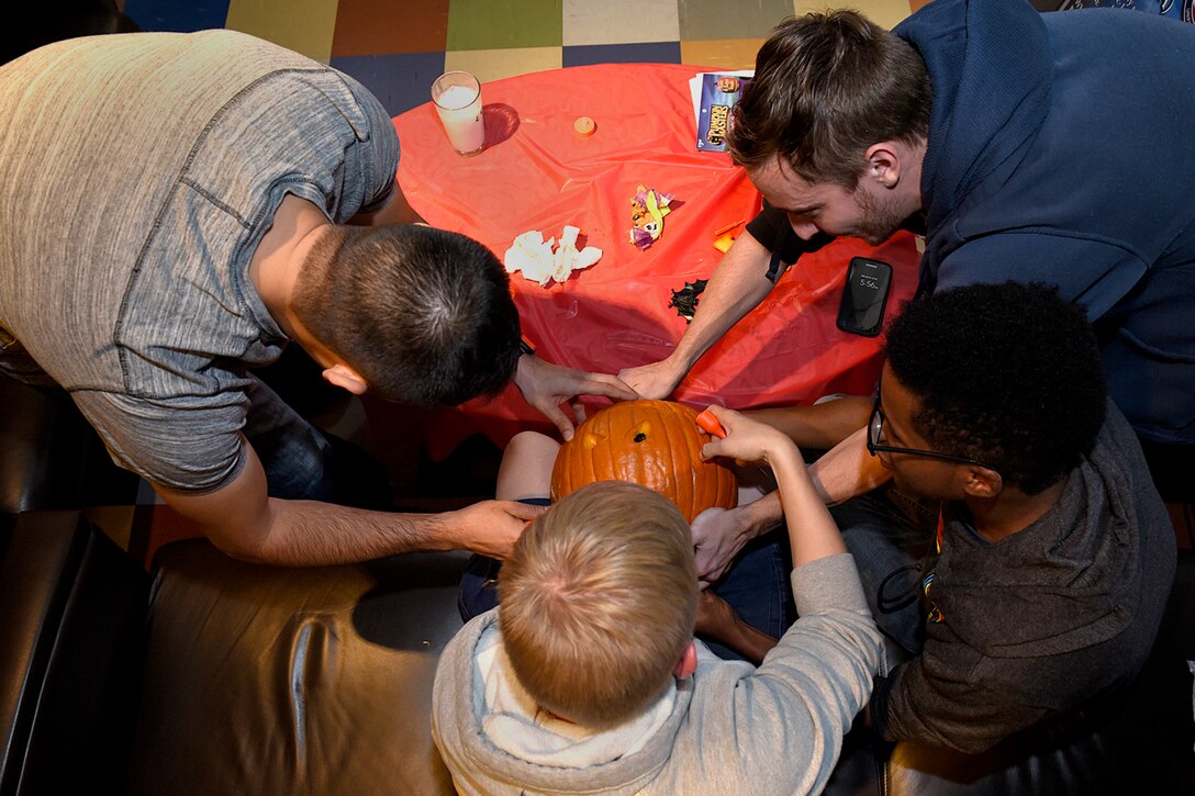 PETERSON AIR FORCE BASE, Colo. – A team from the 721st Communications Squadron at Cheyenne Mountain Air Force Station begin carving a pumpkin at the 4th Annual Pumpkin Carving Contest at the Eclipse Cyber Café on Peterson Air Force Base, Colo., Oct. 26, 2016. The event was put on by the base chapel and sponsored by Ent Bank. (U.S. Air Force photo by Senior Airman Rose Gudex)
