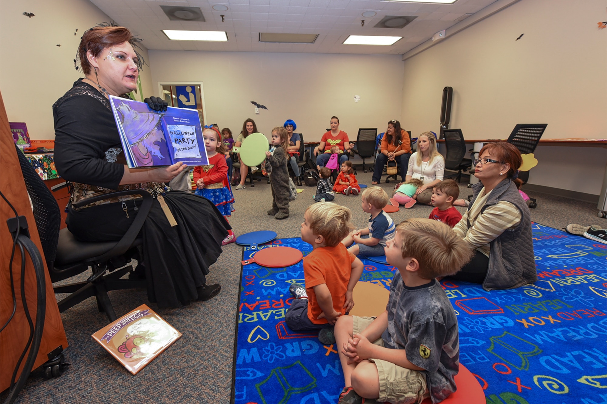 PETERSON AIR FORCE BASE, Colo. – Rebecca Perkins, Peterson Air Force Base Library director, reads stories at Halloween Storytime held at the base library on Peterson AFB, Colo., Oct. 26, 2016.  The kids and their parents listened intently as Perkins read out loud and helped them get in the Halloween spirit. (U.S. Air Force photo by Philip Carter)