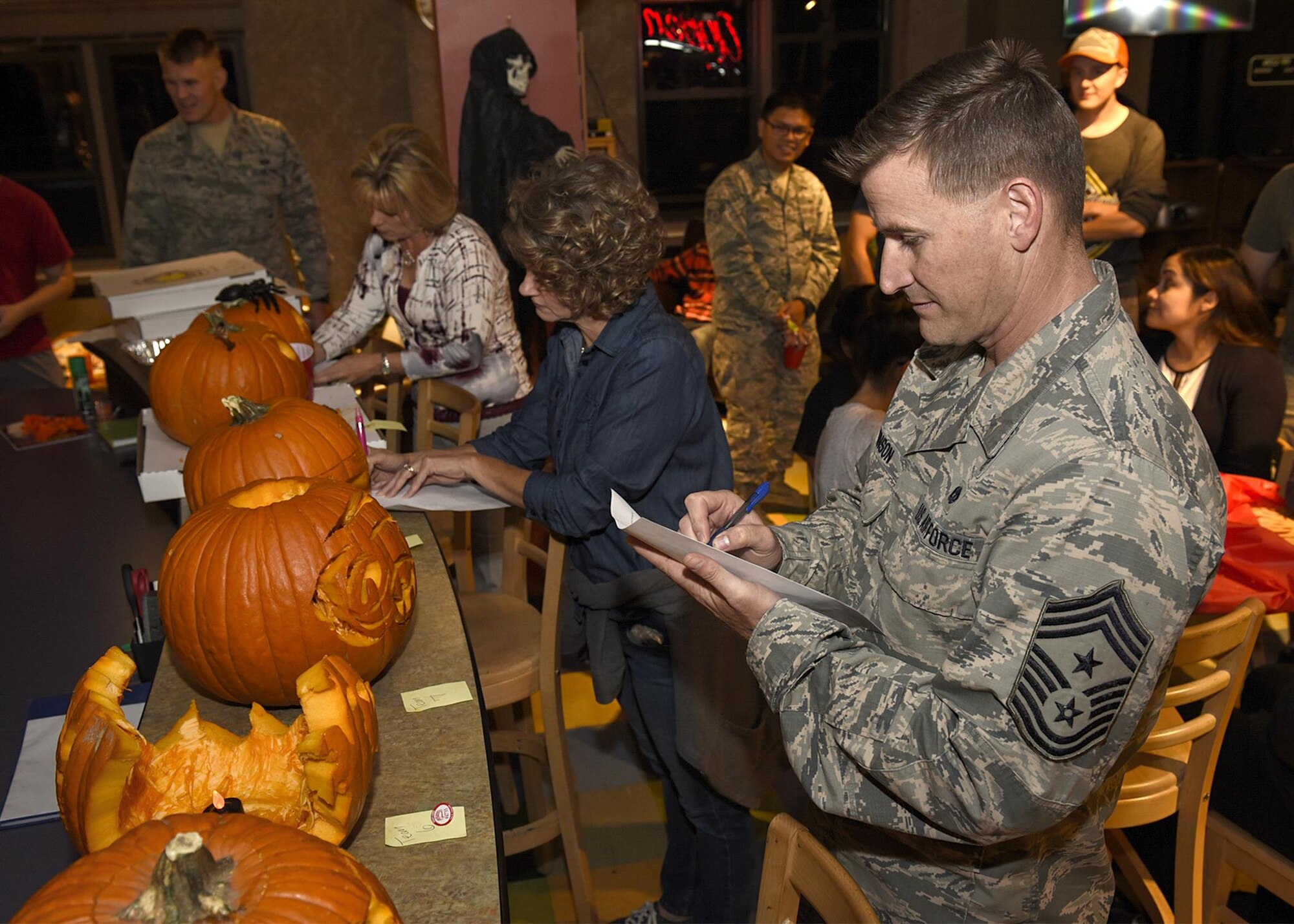 PETERSON AIR FORCE BASE, Colo. – Chief Master Sgt. Mark Bronson, 21st Space Wing command chief, and other wing leadership judge the base chapel’s 4th Annual Pumpkin Carving Contest held at the Eclipse Cyber Café at Peterson Air Force Base, Colo., Oct. 26, 2016. The event encouraged camaraderie and was a time for families to enjoy the Halloween spirit. (U.S. Air Force photo by Senior Airman Rose Gudex)