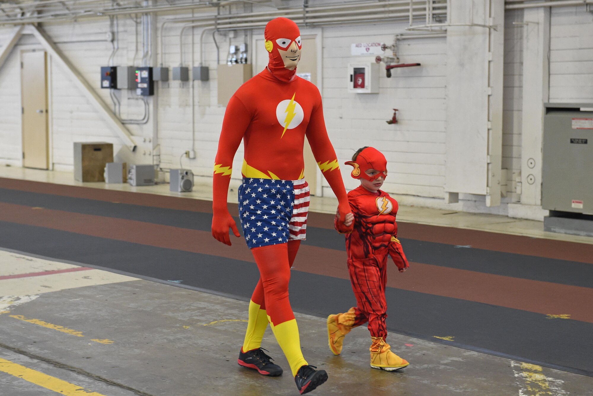 Service members and families participate in a costume fun run in Hangar 5 at Joint Base Elmendorf-Richardson, Alaska, Oct. 28, 2016. The run was a mile long and prizes were awarded to the top three finishers as well as best adult and child costumes. 