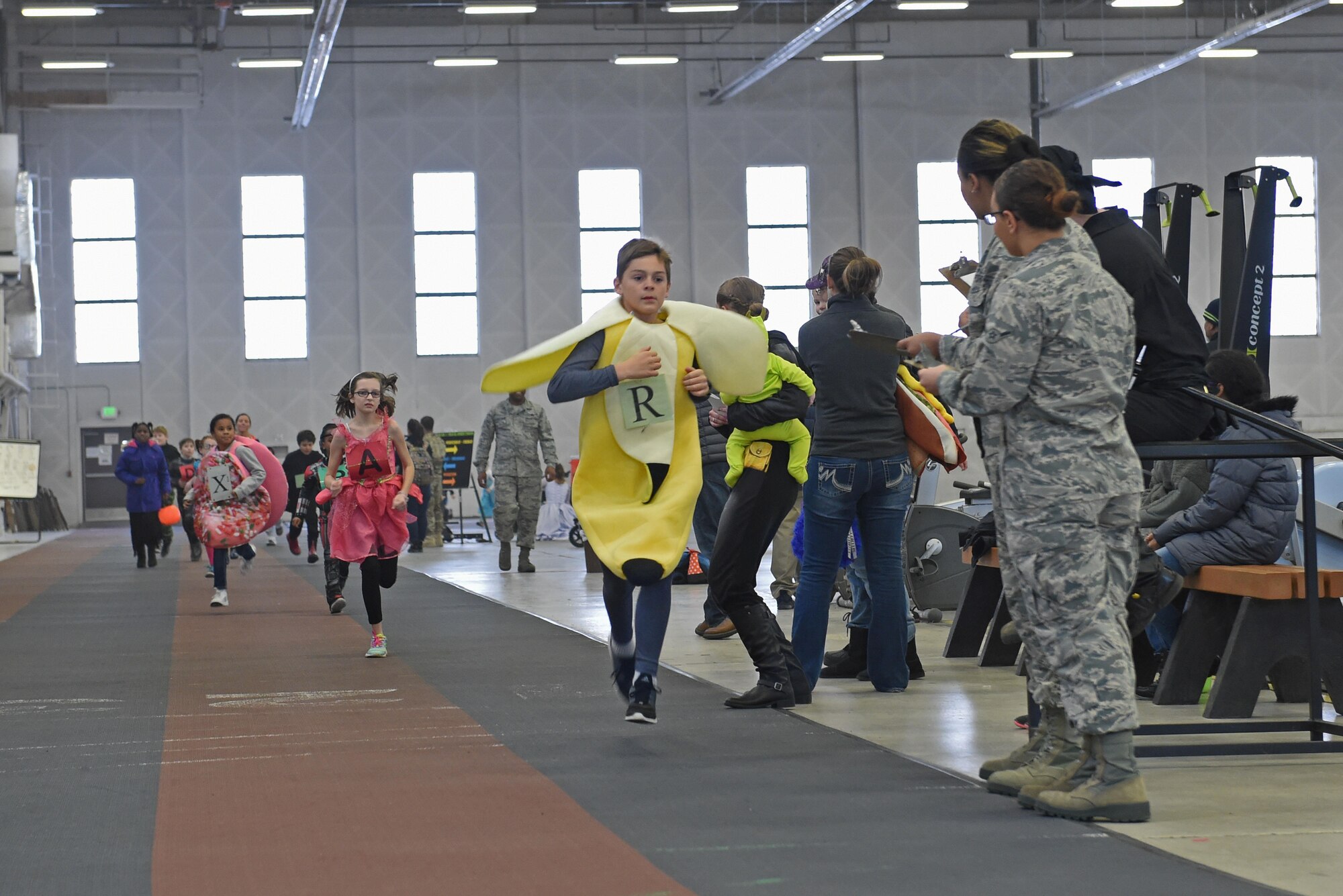 Service members and families participate in a costume fun run in Hangar 5 at Joint Base Elmendorf-Richardson, Alaska, Oct. 28, 2016. The run was a mile long and prizes were awarded to the top three finishers as well as best adult and child costumes. 
