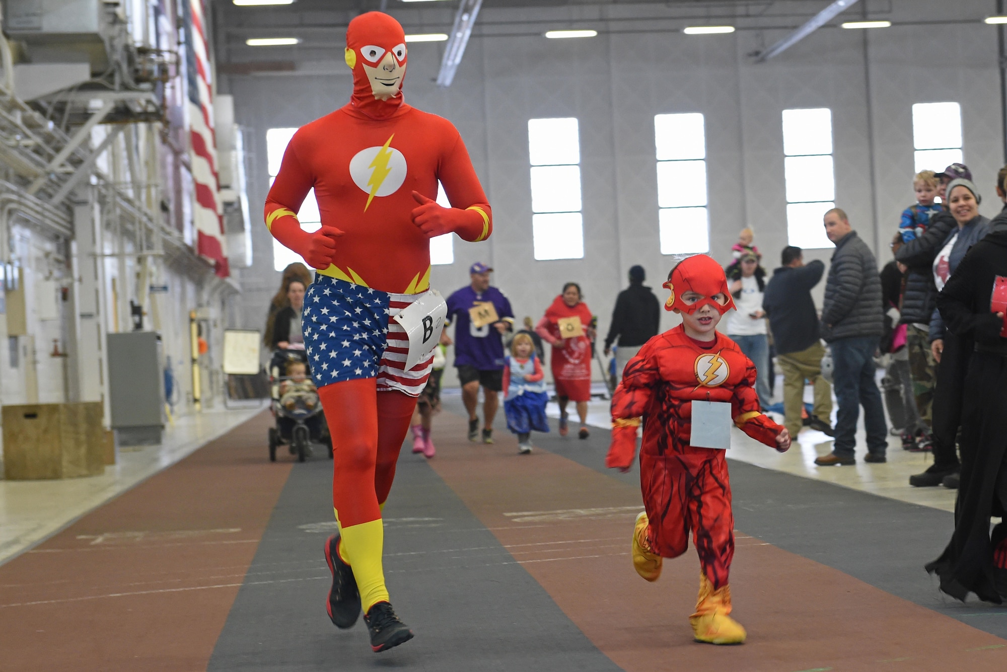 Service members and families participate in a costume fun run in Hangar 5 at Joint Base Elmendorf-Richardson, Alaska, Oct. 28, 2016. The run was a mile long and prizes were awarded to the top three finishers as well as best adult and child costumes. 