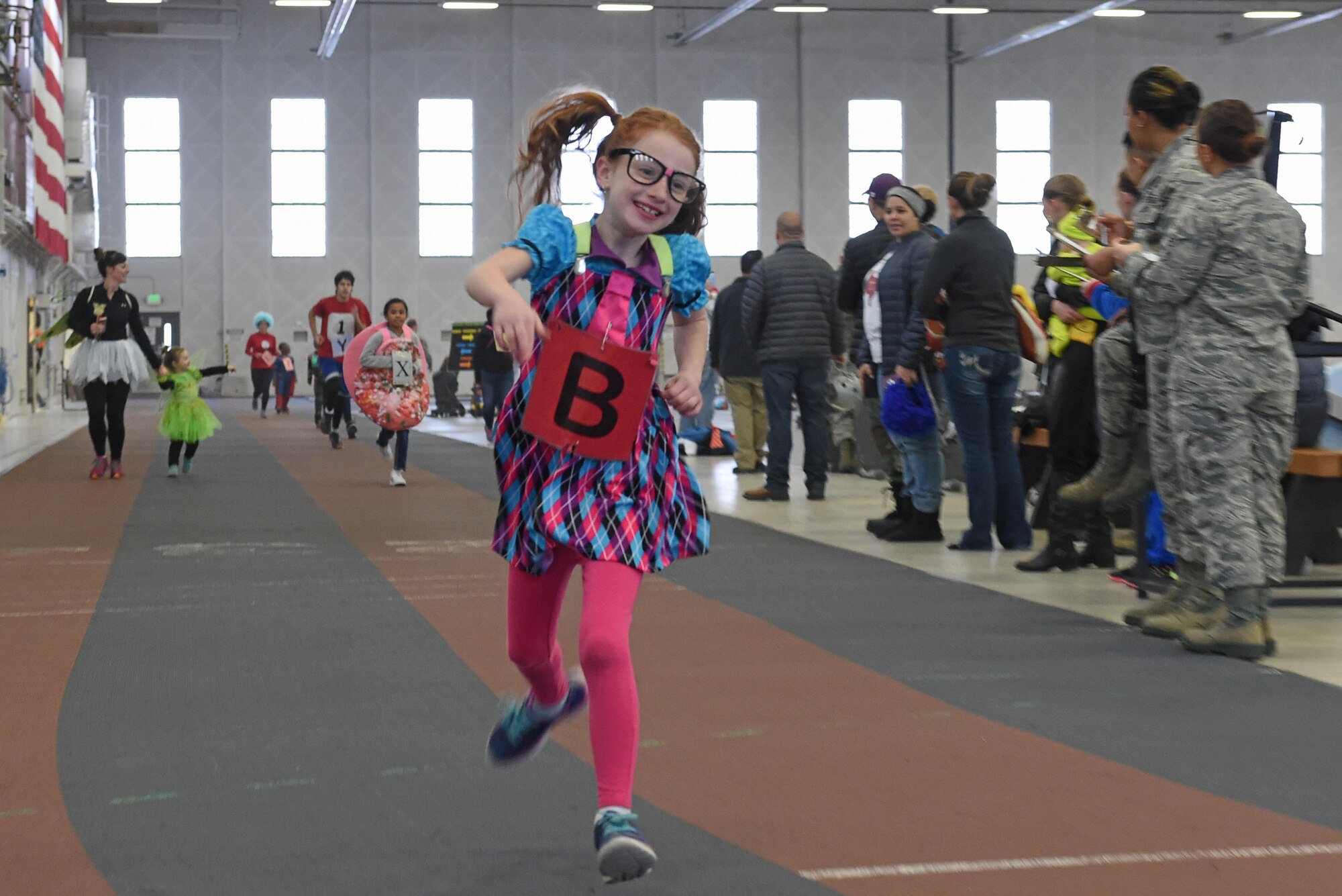 Service members and families participate in a costume fun run in Hangar 5 at Joint Base Elmendorf-Richardson, Alaska, Oct. 28, 2016. The run was a mile long and prizes were awarded to the top three finishers as well as best adult and child costumes. 