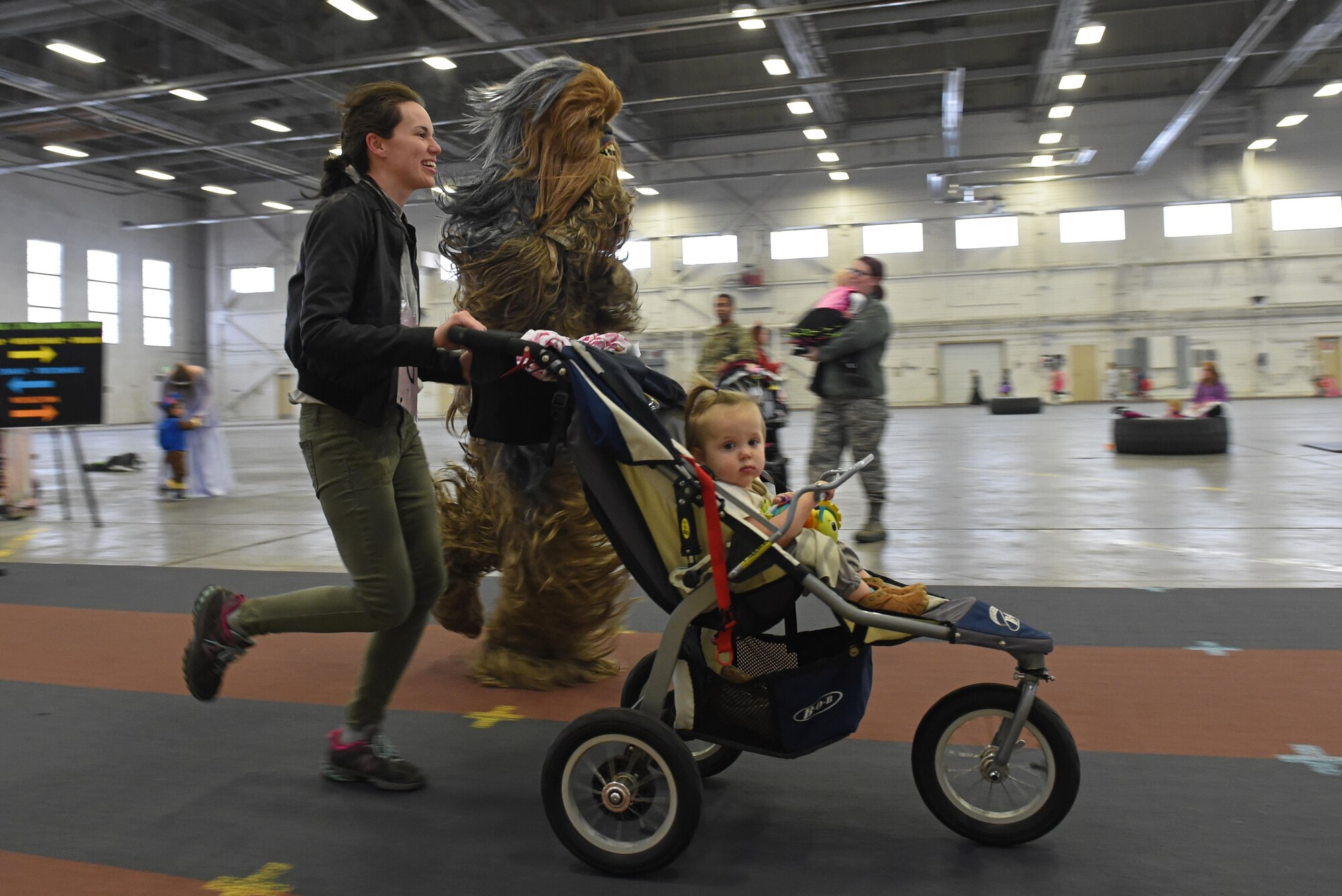 Service members and families participate in a costume fun run in Hangar 5 at Joint Base Elmendorf-Richardson, Alaska, Oct. 28, 2016. The run was a mile long and prizes were awarded to the top three finishers as well as best adult and child costumes. 