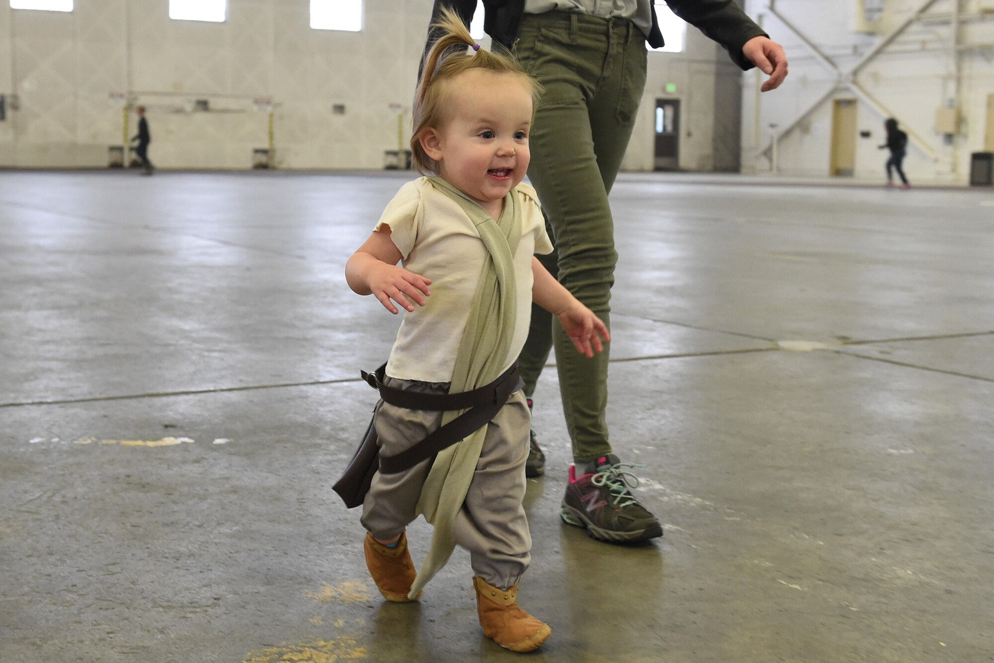 Kiera Jenky, 16 months, runs to greet her father during a costume fun run in Hangar 5 at Joint Base Elmendorf-Richardson, Alaska, Oct. 28, 2016. The run was a mile long and prizes were awarded to the top three finishers as well as best adult and child costumes. 