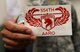Each member of the Assault Assessment and Repair Operations Team (AARO) is presented with a  logo, patch and certificate once thier training is complete. AARO is a 21-member team civil engineering team from the 554th RED HORSE Squadron that uses helicopters and fixed wing aircraft to rappel and fast-rope to battle-damaged areas to repair airfields and other construction projects. (U.S. Air Force photo by Master Sgt. JT May III)
