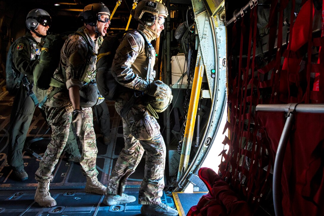 A jumpmaster signals "go" to an airman exiting a C-130 Hercules aircraft during a static line jump over Yokota Air Base, Japan, Oct. 26, 2016. Air Force photo by Airman 1st Class Donald Hudson