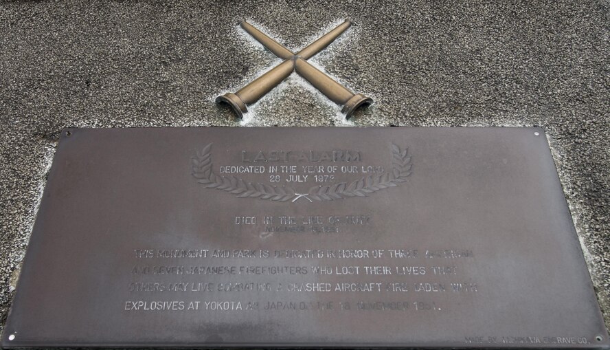 A last alarm memorial rests outside the 374th Civil Engineer Squadron firehouse at Yokota Air Base, Japan, Aug. 30, 2016, paying tribute to Airmen and Japanese firefighters who lost their lives combatting a crashed aircraft fire. The last alarm, sometimes referred to as the last call, is a firefighter funeral tradition honoring members who died in the line-of-duty. In the past, firefighters began and ended their shifts and responded to emergencies at the sound of a bell, so during the ceremony a bell is rung signifying that the departed have completed their duties and can rest. (U.S. Air Force photo by Senior Airman David C. Danford/Released)