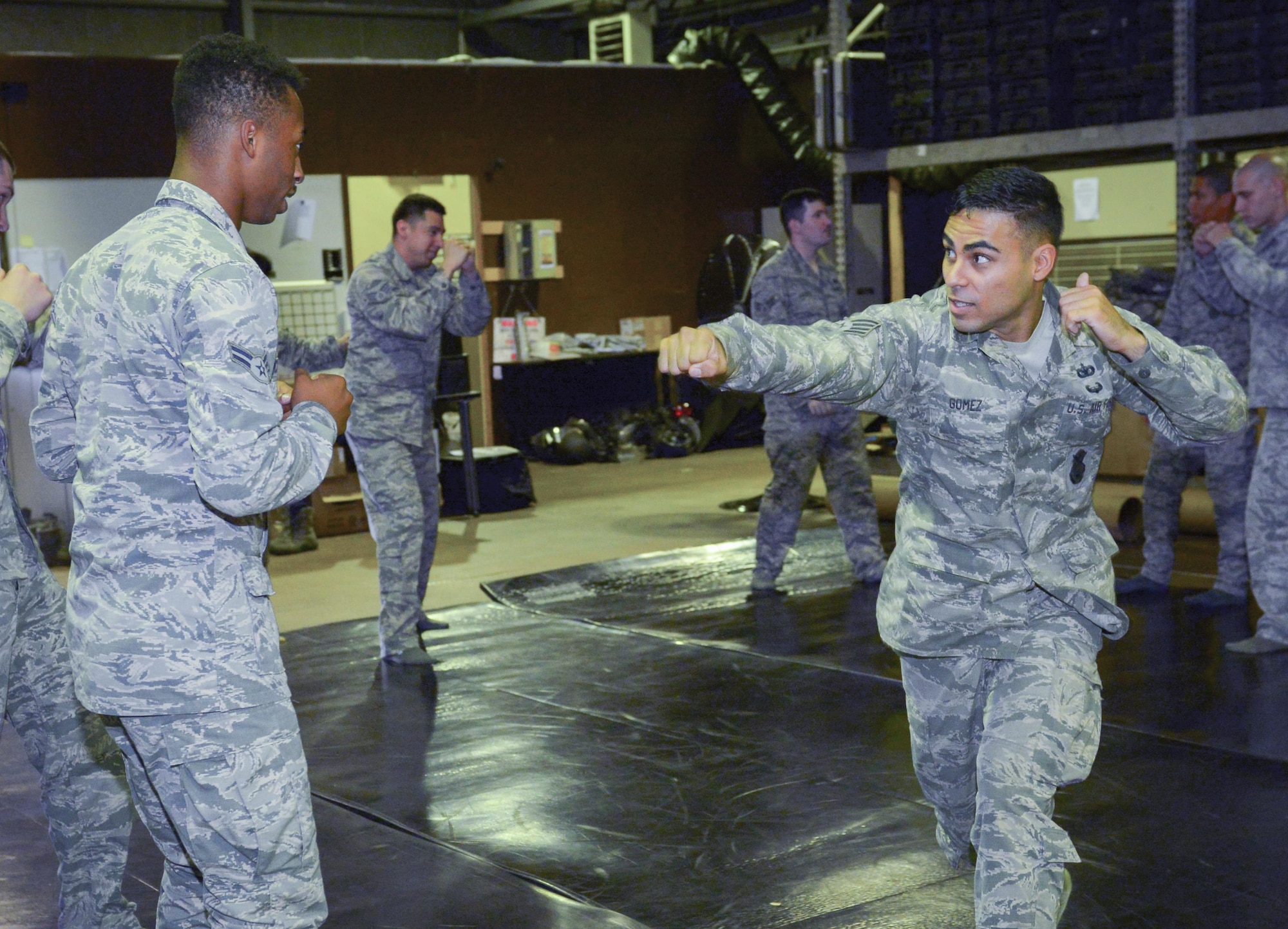 Staff Sgt. Oscar Gomez, 374th Security Forces Squadron flight chief, instructs squadron members on combatives techniques at Yokota Air Base, Japan, Aug. 16 2016. Combatives is a program that teaches personnel how to defend themselves and others without causing or sustaining injury, helping them defend Yokota safely and effectively. (U.S. Air Force photo by Airman 1st Class Baker/Released)