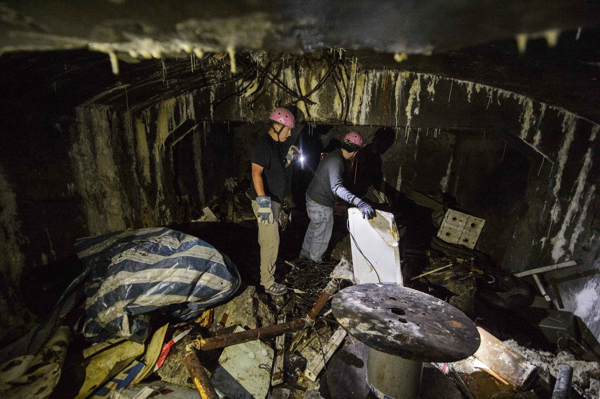 Staff Sergeant Jerrick Gentz, 52nd Logistics Readiness Squadron, left, and Senior Airman Justin Mickle, 52nd LRS, separate and collect scrap metal and debris in Fort Aubin-Neufchateau, Belgium, Aug. 28, 2016. The removal of scrap metal and debris from the bunker rooms will help open more of the bunker for the public tours. (U.S. Air Force photo by Staff Sgt. Jonathan Snyder/Released)