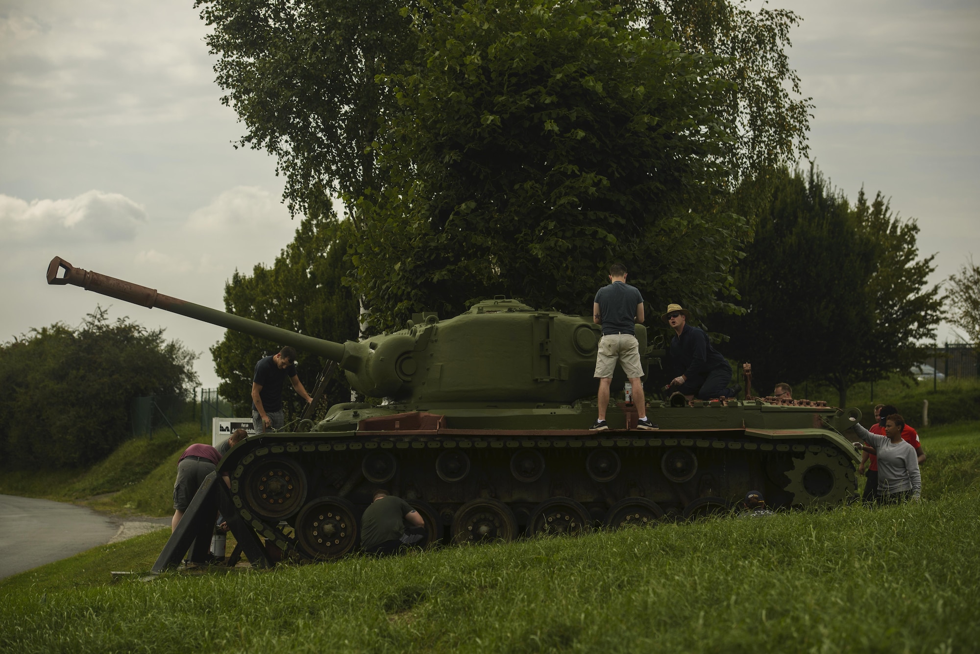 Airmen from the 52nd Logistics Readiness Squadron help paint an M4 Sherman tank in front of Fort Aubin-Neufchateau, Belgium, Aug. 28, 2016. More than 25 Airmen worked to help preserve and excavate a World War II era bunker. (U.S. Air Force photo by Staff Sgt. Jonathan Snyder/Released)