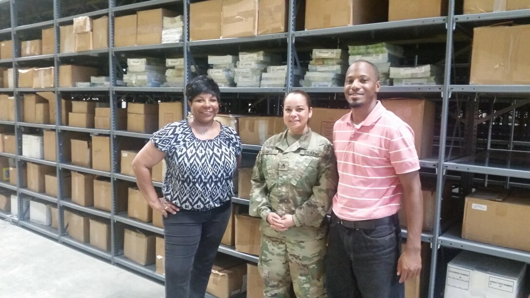DLA Distribution Mapping at Fort Bragg employees, left to right, Marnetia Page, Army Staff Sgt. Monica Sotobenavides and Benedict Beason in Distribution’s warehouse, which provides 10,000 square ft. of acclimatized, racked bay storage for mapping products.   