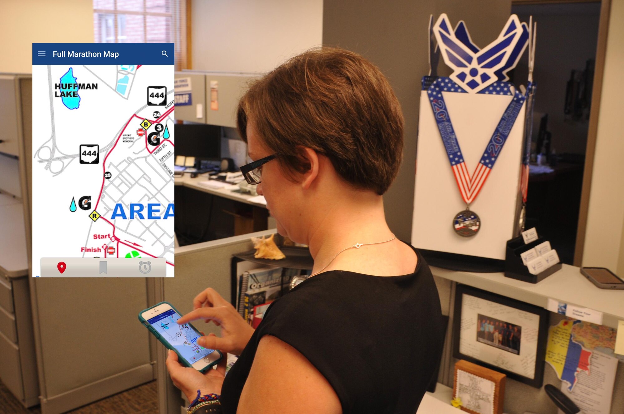 Rachael McKinney, U.S. Air Force Marathon staff member, demonstrates some of the features on the Air Force Marathon app. The app provides up-to-date information about marathon events. (U.S. Air Force Photo Illustration/Jim Mitchell)