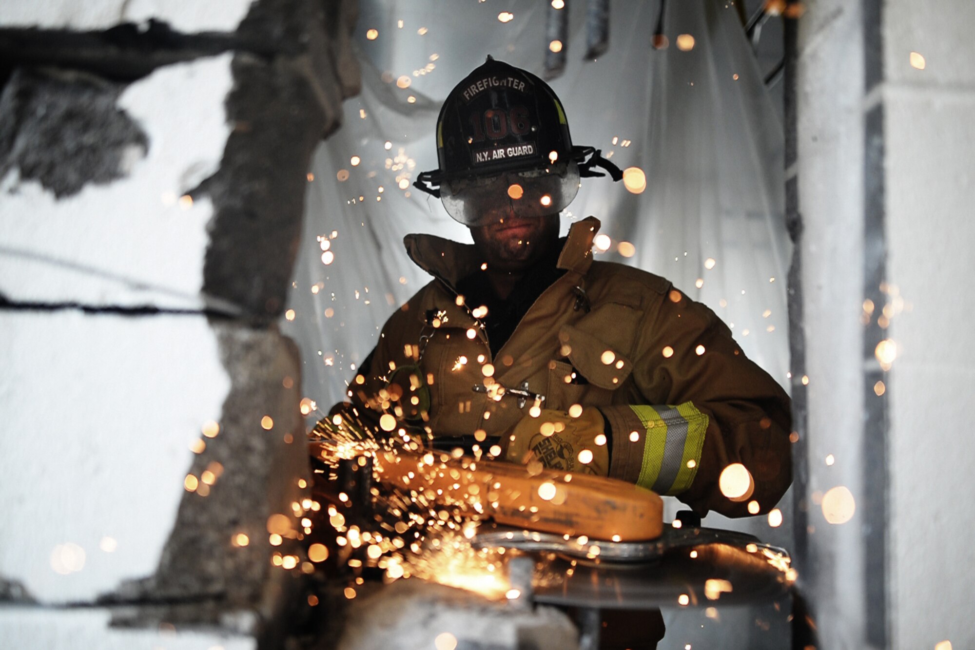Staff Sgt. Daniel Glenn, a firefighter with the 106th Rescue Wing, operates a powered saw in order to cut through a reinforced cinder block wall at Francis S. Gabreski Air National Guard Base, N.Y., Aug. 25, 2016. (U.S. Air National Guard photo/Staff Sgt. Christopher S. Muncy)